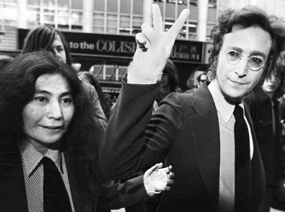 Yoko Ono with John Lennon giving the peace sign