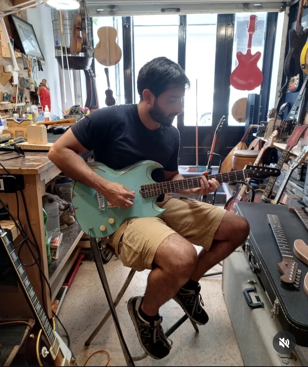 Anthony AKL playing guitar in a workshop